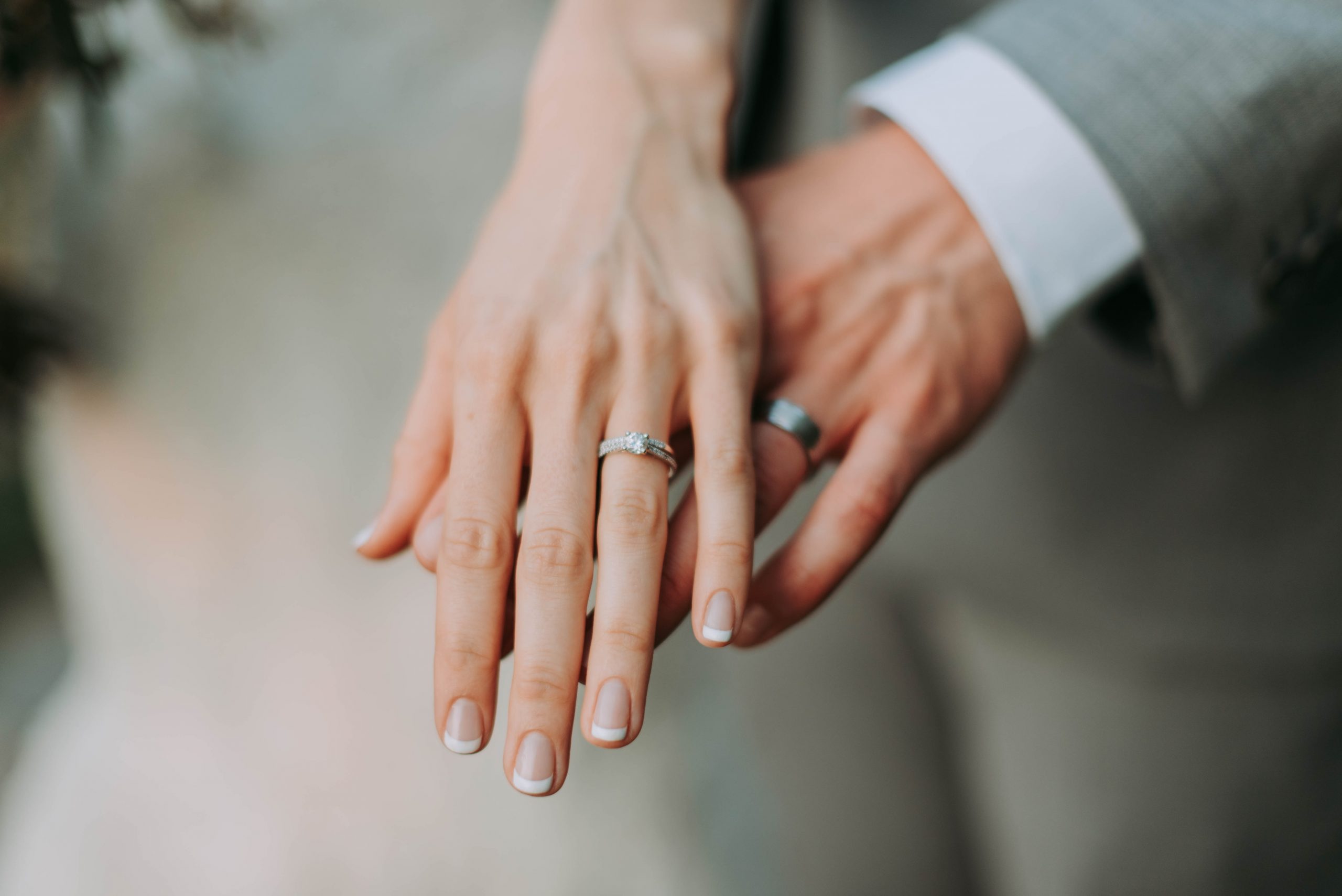 a close-up of a wedding ring being held by a hand