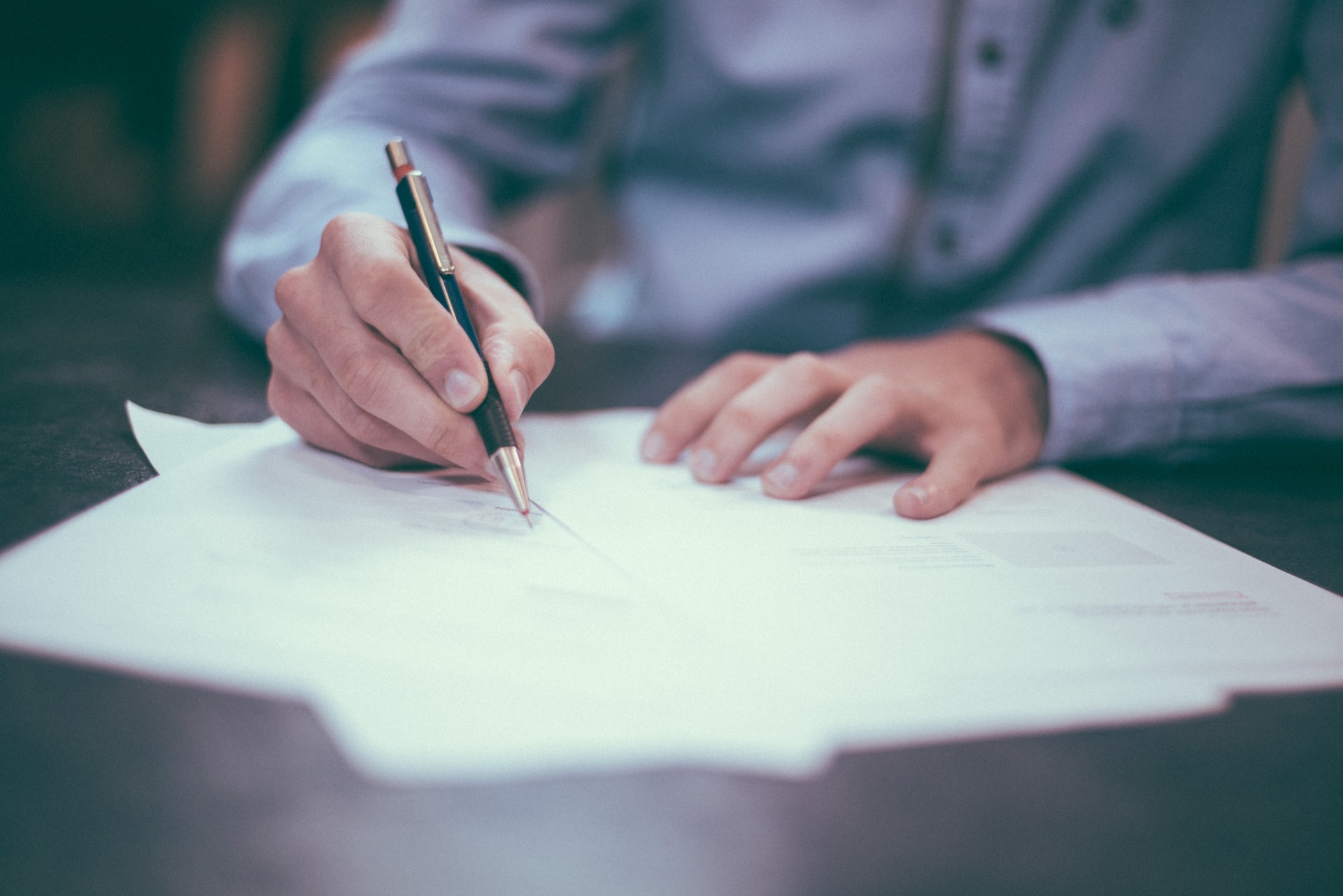 a person writing on a piece of paper