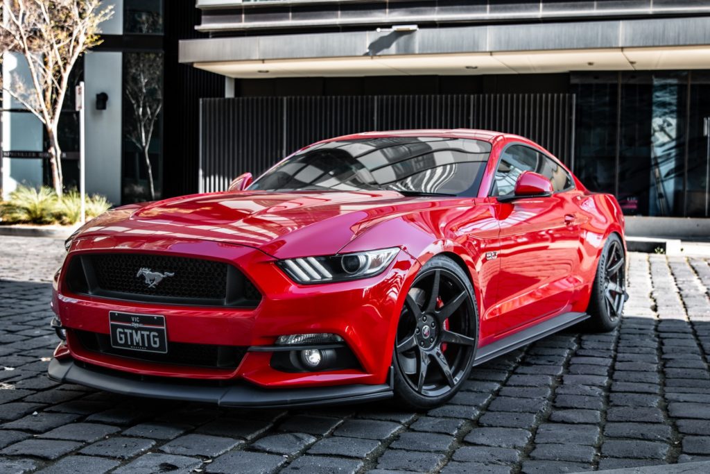 a red car parked on a brick road