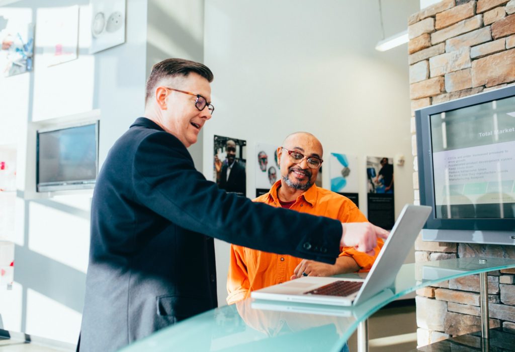 a man pointing at a laptop