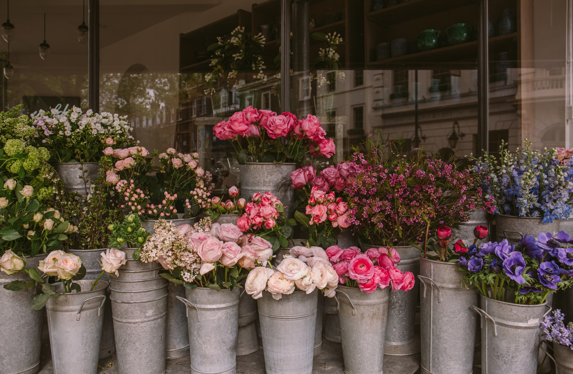 a group of white vases with pink and white flowers in them