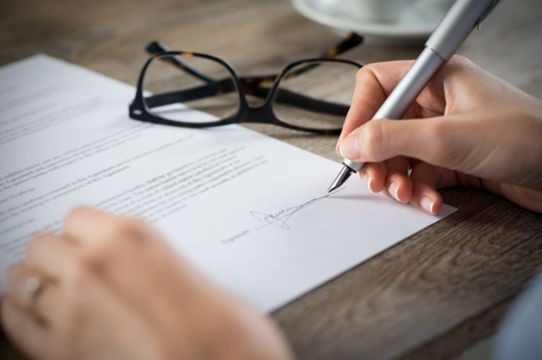 a person writing on a piece of paper