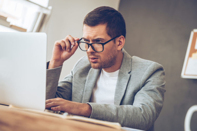 man thinking in front of a laptop